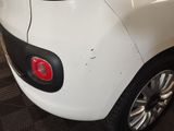a small white car that is parked in a garage