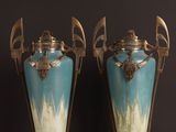 two vases sitting on a table with a black background