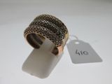 une image représentant une bague en or sertie de diamants noirs sur un fond blanc
