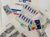a pile of postages on a table with other stamps