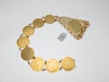 a close up of a bracelet with gold coins on a white surface