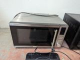 two microwaves that are sitting on the floor next to each other