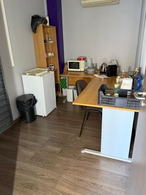 une chambre équipée d'un bureau et d'un réfrigérateur