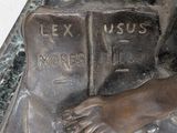 a bronze statue of a boy reading a book