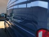 the rear end of a blue van parked in a parking lot