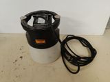a black and white sprayer sitting on top of a counter next to a white wall