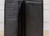 a black leather wallet sitting on top of a wooden table