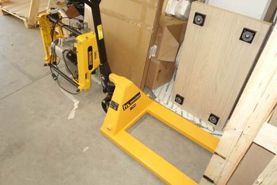a fork lifter sitting next to a pallet in a warehouse