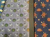 three ties with different designs on them on a table