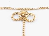 a close up of a gold necklace with an arrow on a chain