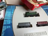 a toy train set on a table next to a box of books
