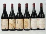 six bouteilles de vin sont alignées sur une table