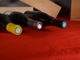 several bottles of wine are lined up on a red table cloth
