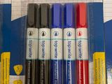 four markers in the package on the table