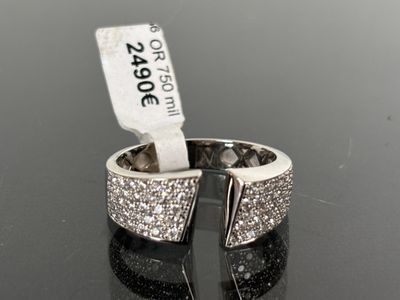 an image of a silver ring with diamonds on a black surface