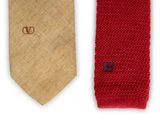 two neck ties with a monogram on them sitting next to each other