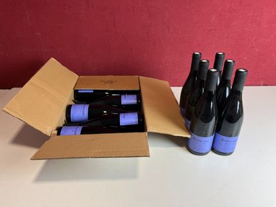 six bouteilles de vin dans un carton sur une table