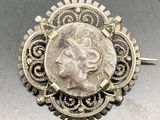 une image représentant une pièce d'argent en forme de broche