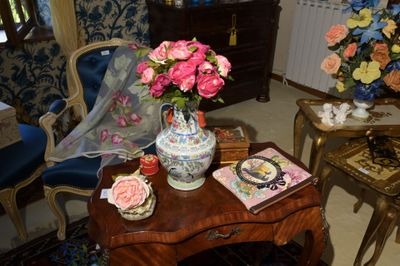 une table sur laquelle se trouvent un vase de fleurs et un livre