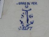 une assiette bleue et blanche sur laquelle est représentée une ancre