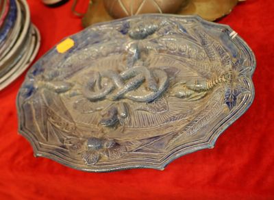 a plate with a fish design on it on a red table