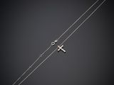 un collier en argent avec une croix et une chaîne sur fond noir