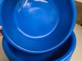 two blue plastic bowls stacked on top of each other on a counter