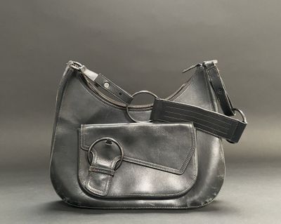 grey leather purse with a black strap on a gray background