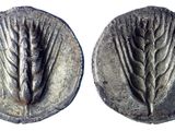 a close up of two silver coins with leaves on them
