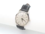 une montre argentée et noire posée sur une surface blanche