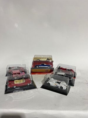 quatre petites voitures sont alignées sur une surface blanche