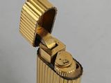 a close up of a gold colored lighter on a white surface