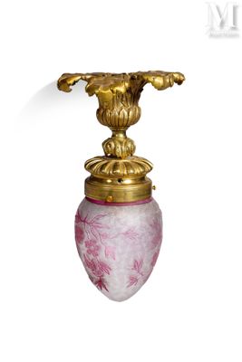 un vase rose avec une anse dorée sur fond blanc
