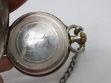 a person holding a silver pocket watch in their hand