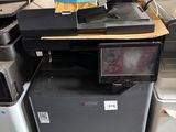 une pile d'imprimantes et de scanners de bureau posée par terre