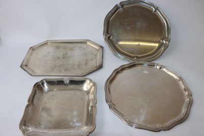 trois plateaux en argent avec couvercles et poignées, posés sur une surface blanche