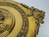 a gold plate with a picture of a woman on it