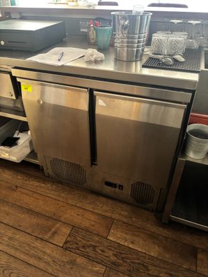 une cuisine en inox équipée d'un évier et d'un réfrigérateur