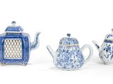 trois théières bleues et blanches et un panier sur la table