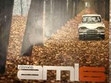 une photo d'une voiture qui roule à travers les bois
