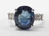 gros plan d'une bague avec un saphir bleu entouré de diamants blancs