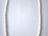 gros plan d'un collier de perles sur une surface blanche
