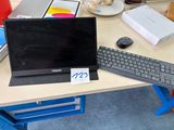 un ordinateur portable posé sur un bureau, avec un clavier et une souris dessus
