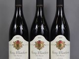 trois bouteilles de vin sont alignées sur une table
