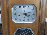 une horloge posée par terre à côté d'une boîte