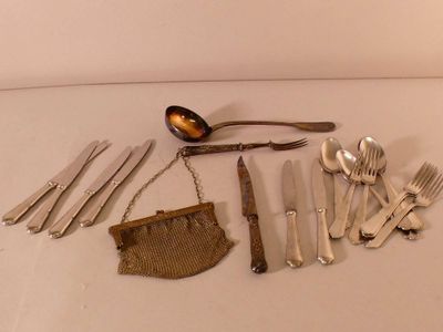 a lot of silverware on a table with a purse