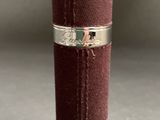 a red leather tube with a silver band on it