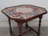 a small wooden table with a floral design on it