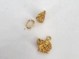 a pair of gold plated earrings on a white surface