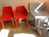 two red chairs sitting next to a table in a room